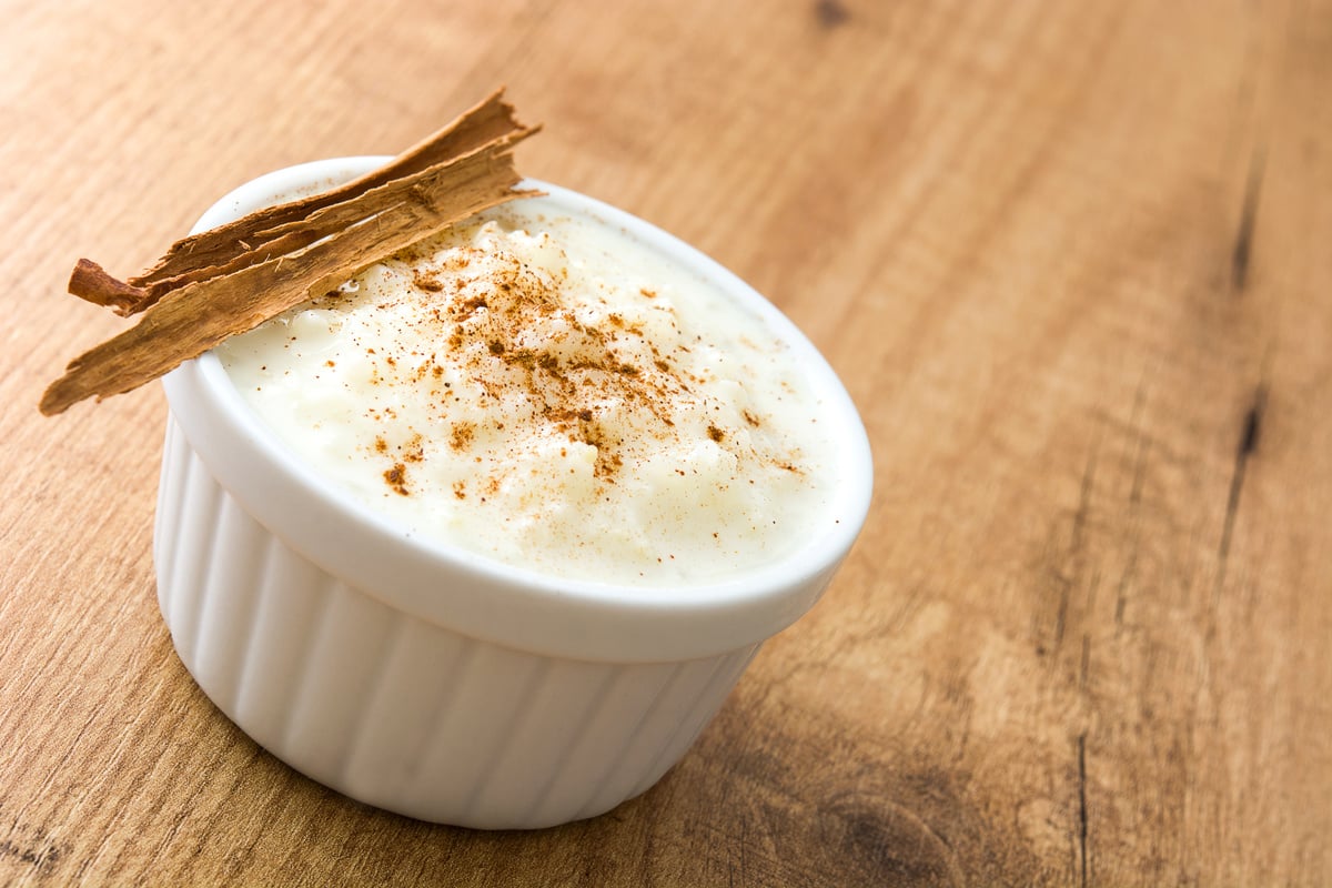 Arroz con leche. Rice pudding with cinnamon on wooden background