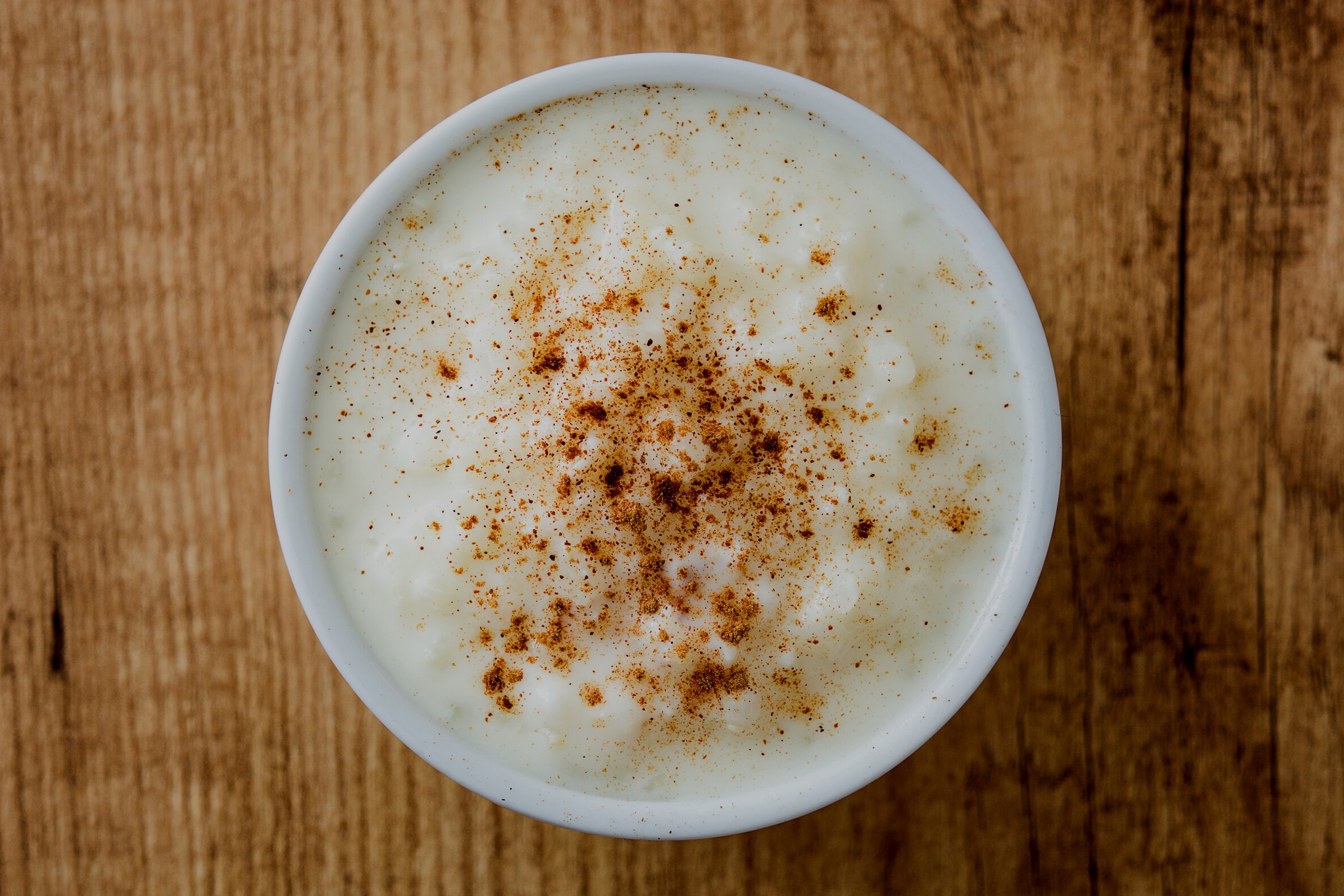 Arroz con leche. Rice pudding with cinnamon on wooden background